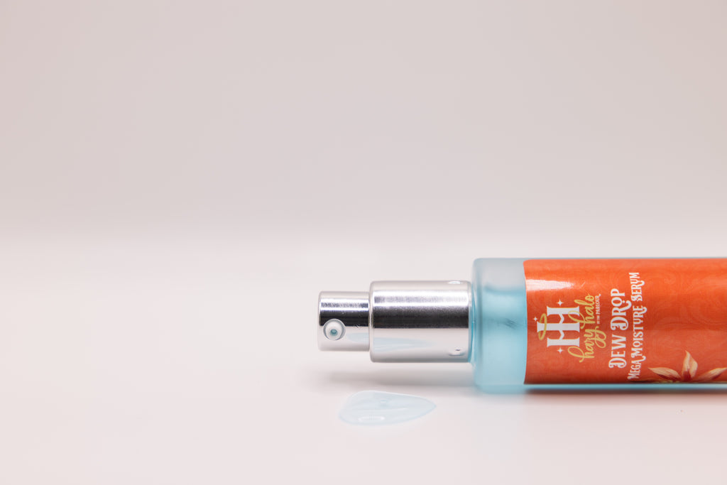 Dew Drop Mega Moisture Serum by The Parlour lying on its side with exposed pump and hydrating gel serum texture pooled in front of the bottle