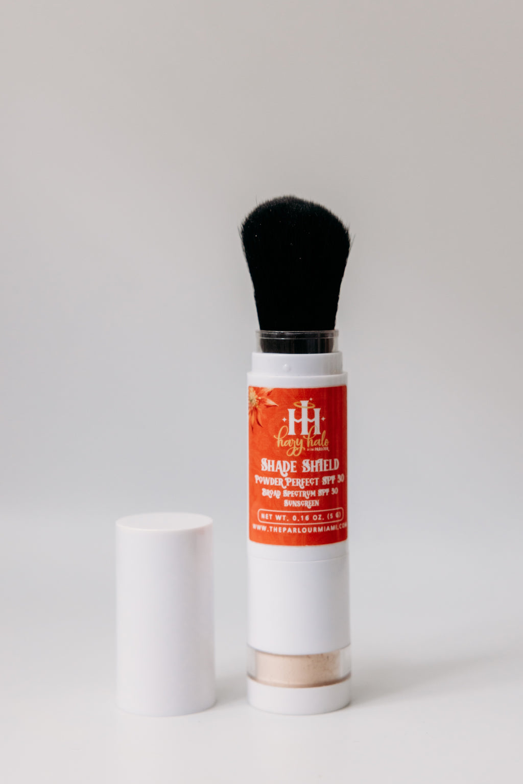 Shade Shield Portable Powder SPF 30 by The Parlour with cap removed showing built-in brush applicator open for lightweight mineral sun protection and shine control