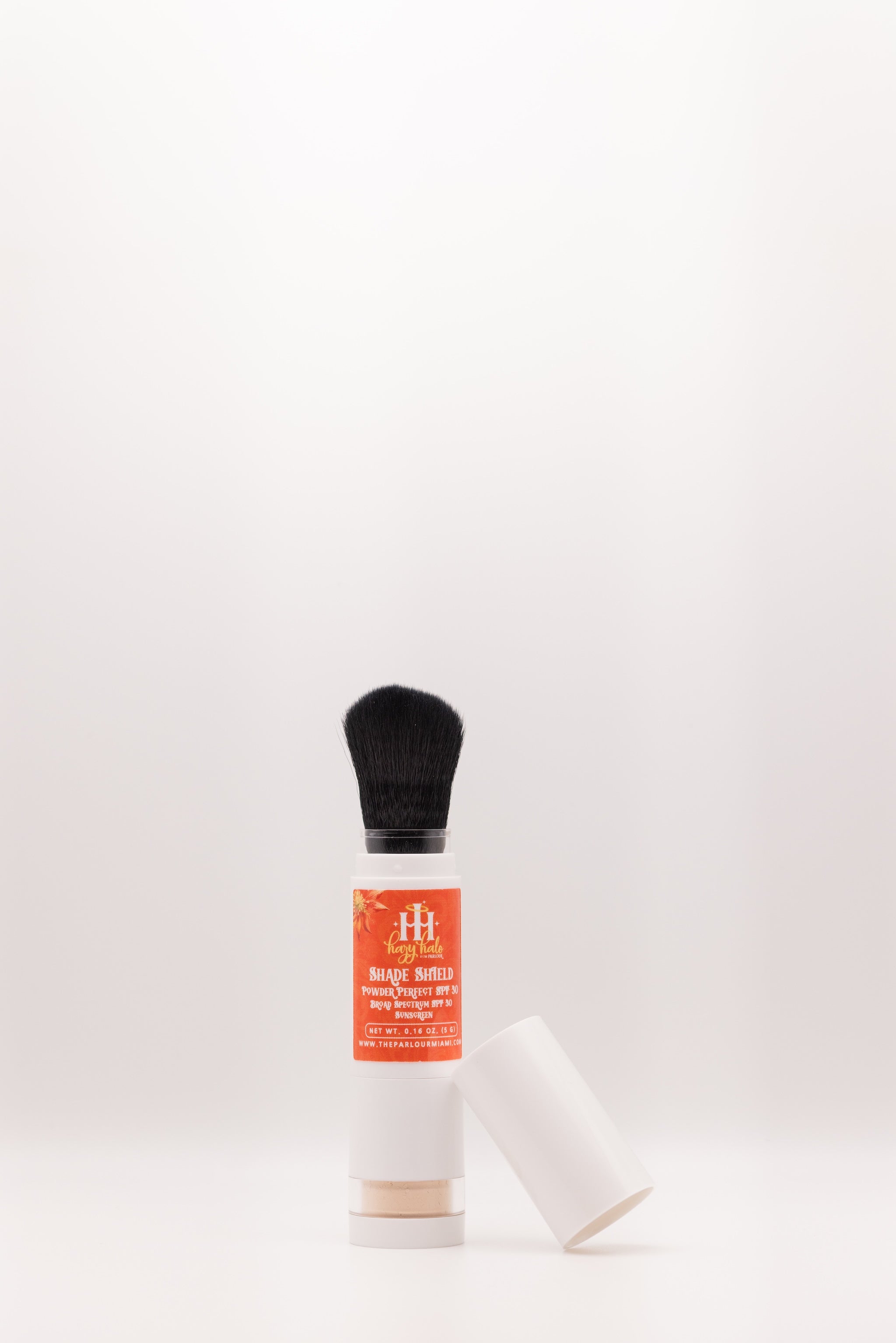 Shade Shield Portable Powder SPF 30 by The Parlour with cap removed showing built-in brush applicator for lightweight mineral sun protection and shine control