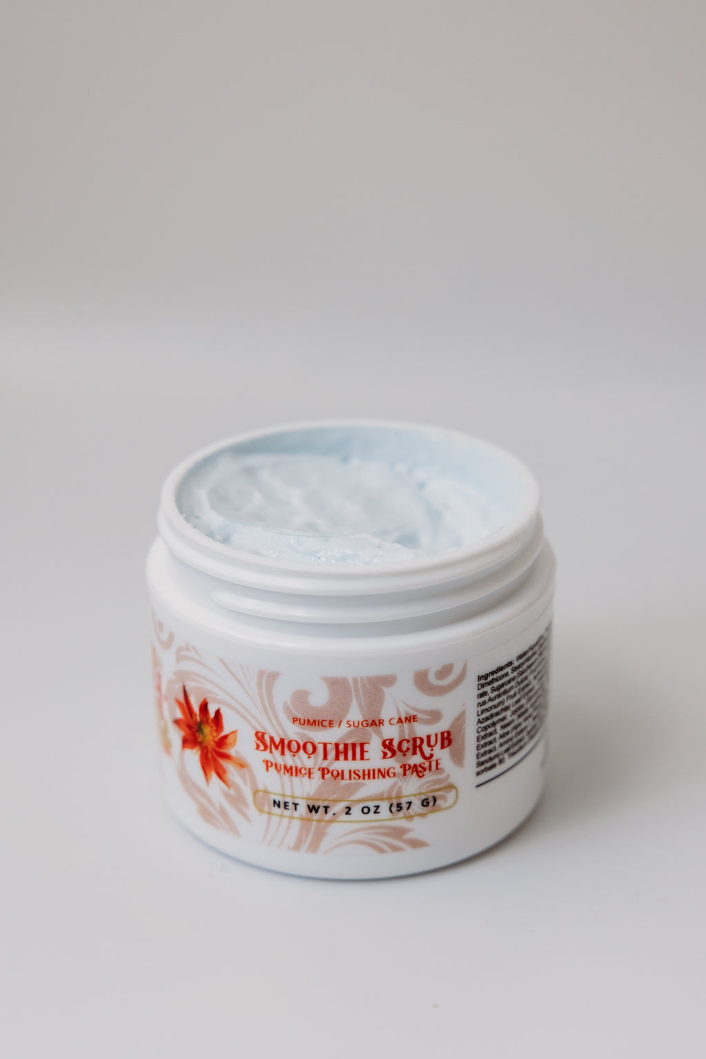 Open jar of Smoothie Scrub pumice polishing paste by The Parlour showing creamy exfoliating texture for smoothing rough skin, brightening dull complexion, and refining uneven texture.